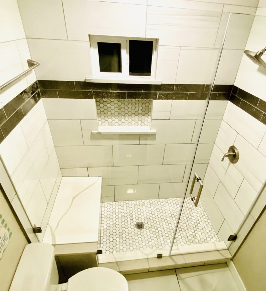 Oak Crest — completed walk-in shower with frameless glass, tiled bench and hex floor tile