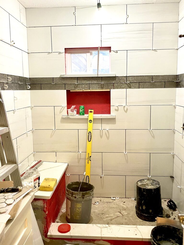 Oak Crest — hex floor tile and shower tile being set